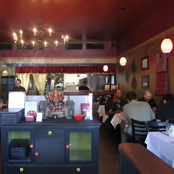 The interior of Batika India Bistro, with patrons dining and a server behind the counter.