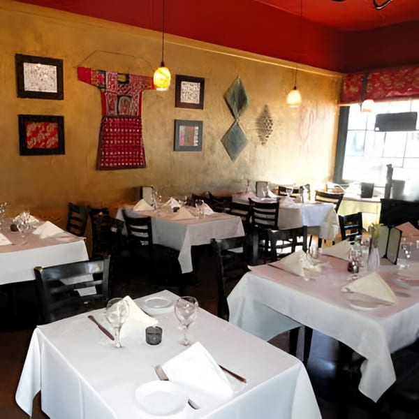Batika India Bistro dining room with white-clothed tables, dark chairs, and Indian-inspired wall decor.