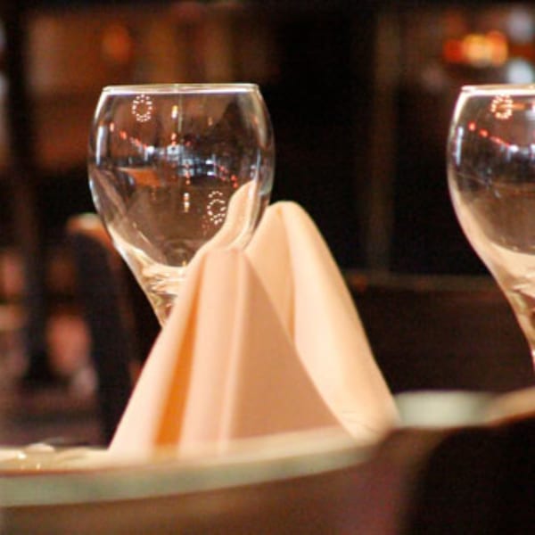 Close-up of a wine glass and folded napkin on a table at Batika India Bistro.